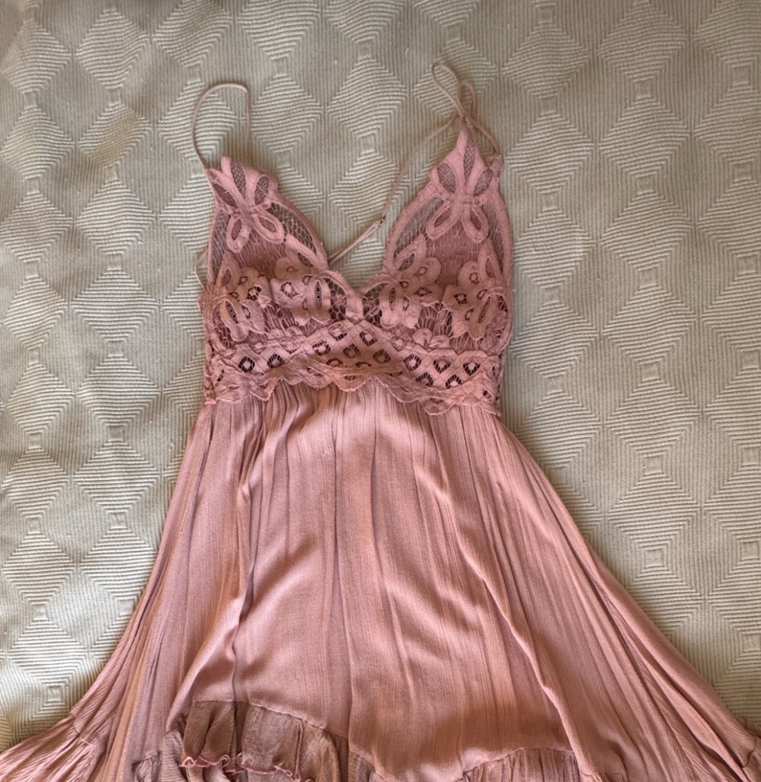 A blush lace slip dress photographed flat at home
